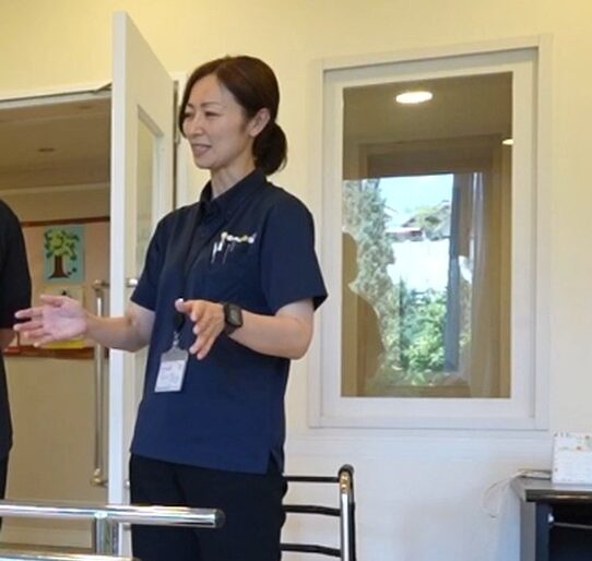 施設内の設備を確認しながら説明する理学療法士の木原