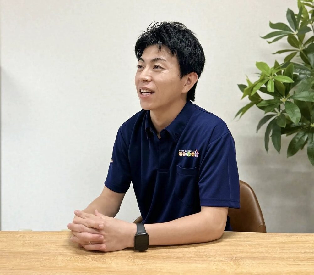 施設での生活について説明する理学療法士の岡村